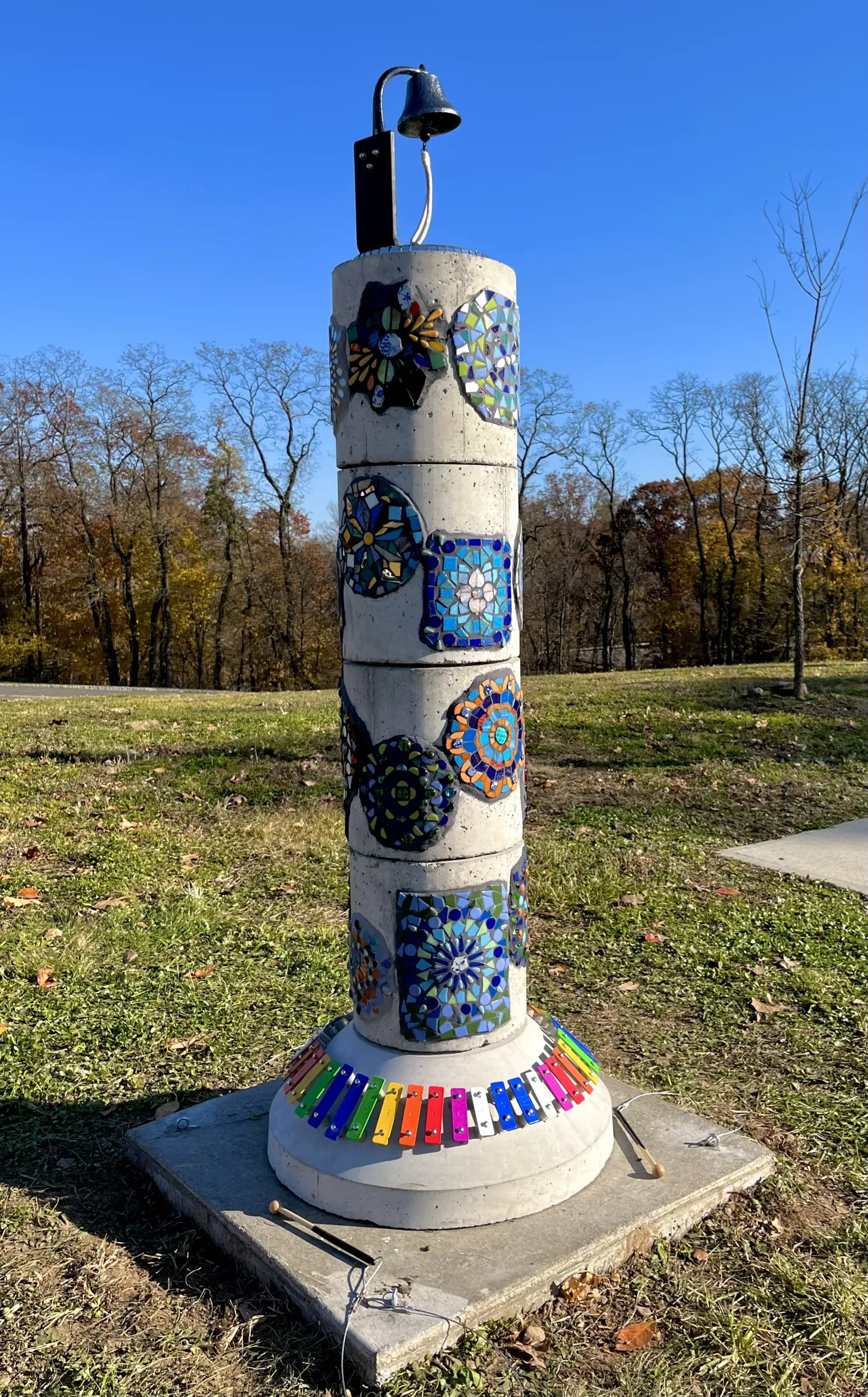 "Sound Column" art is a sculpture w/ mosaics, a bell on top, and xylophone on bottom.