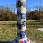 "Sound Column" art is a sculpture w/ mosaics, a bell on top, and xylophone on bottom.